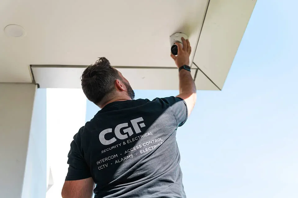 CGF technician installing a security camera under the eaves of a home